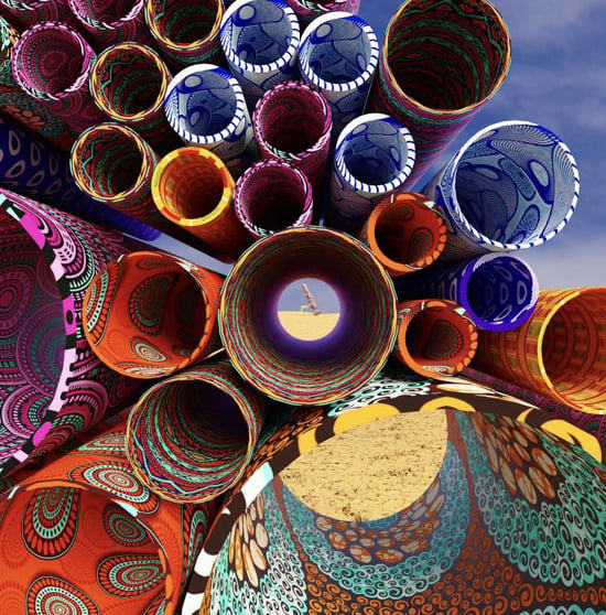 A close up of the art installation by Usha Seejarim called 'Resurrection of the Clothes Peg'. It shows lots of bright, patterned and colourful metallic tubes set in a desert setting. 